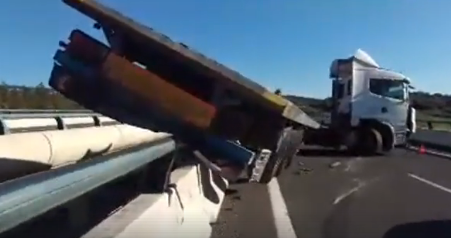 Un camión accidentado pierde la carga y está a punto de precipitarse al vacío